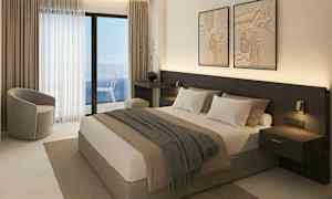 Ett hotellrum med en dubbelsäng, sittmöbler och en balkong med havsutsikt. (AI-genererad text)