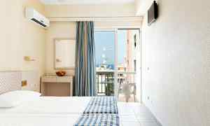 Hotellrum med två sängar, blågula sängöverkast, spegel, och en balkongdörr med utsikt. (AI-genererad text)