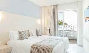 Hotelrum med två enkelsängar och balkong. (AI-genererad text)