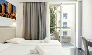 Hotellrum med två enkelsängar, balkong med utsikt. (AI-genererad text)