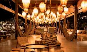 Ett nattligt loungeområde med hängande lampor och sittmöbler. (AI-genererad text)