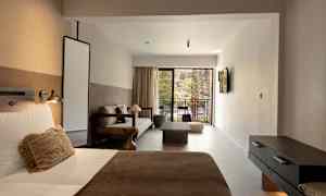 Ett hotellrum med säng, soffa och uteplats. (AI-genererad text)