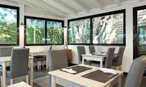 Ett ljust restauranginteriör med glasfönster och sittplatser. (AI-genererad text)