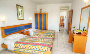 Ett hotellrum med två sängar, en garderob och en byrå med spegel. (AI-genererad text)