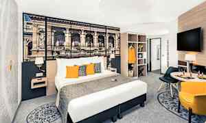 Hotellrum med dubbelsäng, väggdekoration, sittgrupp och garderob. (AI-genererad text)