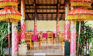 Ett inrett rum med trädetaljer, rosa dekorationer och bord med stolar. (AI-genererad text)