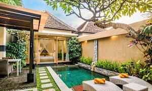 En uteplats med en liten pool omgiven av grönska och ett hus i bakgrunden. (AI-genererad text)