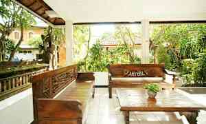 Utomhusterrass med två träbänkar och ett soffbord, omgiven av frodig trädgård. (AI-genererad text)