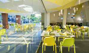 Bild av en modern restaurang med gula stolar och glasväggar. (AI-genererad text)