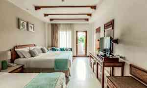 Ett hotellrum med två stora sängar, en TV och ett fönster med ljusinsläpp och balkong. (AI-genererad text)