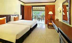 Ett hotellrum med två enkelsängar, ett skrivbord och en balkong med utsikt. (AI-genererad text)