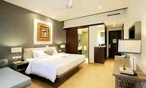 Ett sovrum med en stor säng, en sittgrupp och ett badrum i bakgrunden. (AI-genererad text)