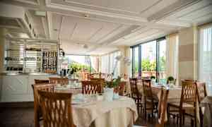 En restaurang med dukade bord och utsikt mot en byggnad med kupol. (AI-genererad text)