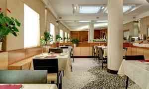 En modern restaurang med uppsatta bord och blommor på varje bord. (AI-genererad text)