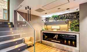 Bildens motiv föreställer en modern hotellreception med en minimalistisk inredning och växtutsmyckning vid disken. (AI-genererad text)