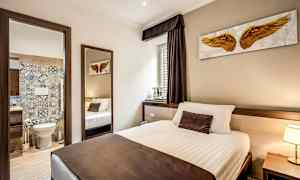 En hotellrumsinteriör med en säng och en öppen dörr till ett badrum. (AI-genererad text)