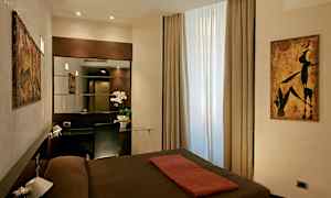 Ett hotellrum med modern inredning, ett fönster med ljusinsläpp, en spegel och en skrivbordsyta med stol. (AI-genererad text)