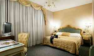 Ett hotellrum med en dubbelsäng, ett skrivbord med stol och en TV. (AI-genererad text)