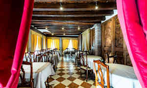 Interiör av restaurang med dukade bord och trästolar. (AI-genererad text)