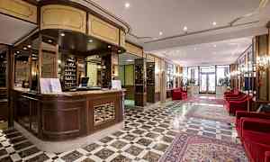 Reception och lobbyområde med marmorgolv och röda soffor. (AI-genererad text)