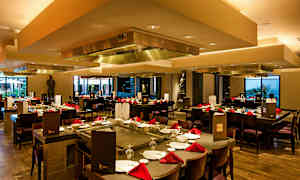 En restaurang med bord uppdukade med rödservetter och stolar runt. (AI-genererad text)