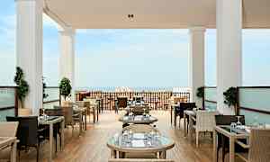 Restaurang med utomhusbord och havsutsikt. (AI-genererad text)