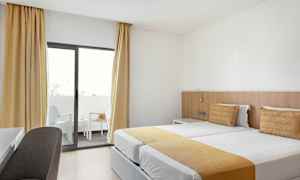 Hotellrum med två enkelsängar och balkong. (AI-genererad text)