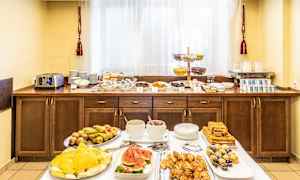 Hotellfrukostbuffé med olika rätter, inklusive frukt, bakverk och drycker. (AI-genererad text)