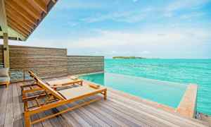 Terrass med två solstolar vid en infinitypool och utsikt över turkost hav. (AI-genererad text)