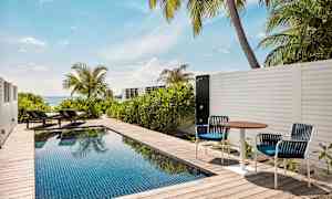 Privat pool på en terrass med solsängar och havsutsikt. (AI-genererad text)