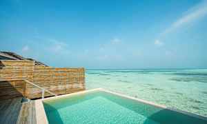 Swimmingpool vid havet med trästaket och klarblå himmel. (AI-genererad text)