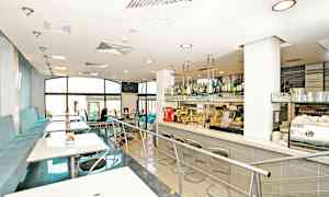 En modern caféinteriör med sittplatser och en bardisk. (AI-genererad text)