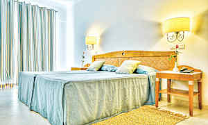 Bild av ett ljust hotellrum med en dubbelsäng och nattygsbord. (AI-genererad text)