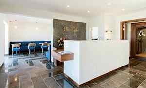 En reception med en marmorbänkskiva och stolar i en lounge. (AI-genererad text)