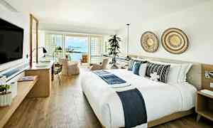 Ett ljust och modernt hotellrum med utsikt över havet. (AI-genererad text)