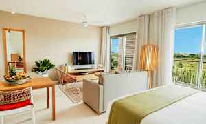 Modernt inredd lägenhet med vardagsrum, matplats, TV och utsikt över grönska. (AI-genererad text)