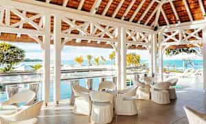 Utsikt över en terrass med vita möbler och havet i bakgrunden. (AI-genererad text)