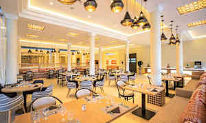 Restaurang med dukade bord och hängande taklampor. (AI-genererad text)