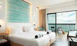 Ett hotellrum med två sängar, balkong och havsutsikt. (AI-genererad text)