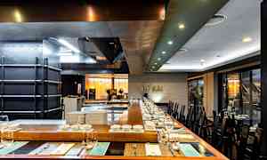 Bild av en modern restaurang med bordsdukning och öppet kök. (AI-genererad text)