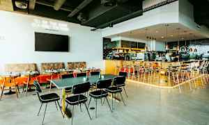 Restauranginteriör med bord, stolar och en bardisk. (AI-genererad text)