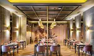 Bild på en elegant restaurang med bord och stolar, moderne inredning och stämningsfull belysning. (AI-genererad text)