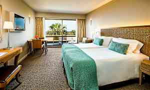 Hotellrum med två sängar och balkong. (AI-genererad text)