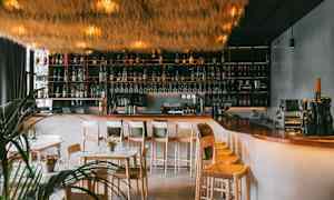 En modern bar med högt i tak och elegant inredning. (AI-genererad text)