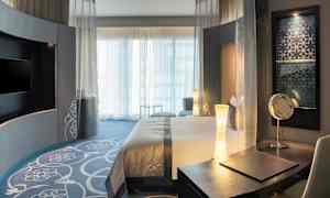 Hotellrum med modern inredning, säng och skrivbord. (AI-genererad text)