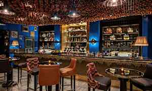 Interiör av en elegant bar med sittplatser och dekorerad tak. (AI-genererad text)