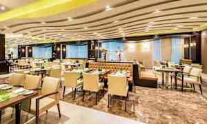 En elegant restaurang med bord och stolar uppställda, samt dekorativ belysning. (AI-genererad text)