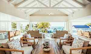 Loungeområde med bekväma sittgrupper och en vy mot havet utanför. (AI-genererad text)