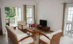 Ett ljust vardagsrum med möbler för fyra personer, ett soffbord och en tv. (AI-genererad text)