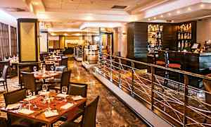 En stilren restaurang med dukade bord, stolar och en bardel. (AI-genererad text)